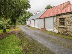 a dirt road in front of two stone buildings at Willowbrook Cottage in Ballyshannon