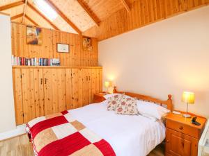 een slaapkamer met een bed en houten lambrisering bij The Dispensary in Killeagh