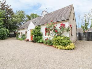 a white house with flowers on the side of it at O'Neill's in Tipperary