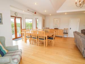 a dining room and living room with a table and chairs at 1 Ard Carraig in Portsalon