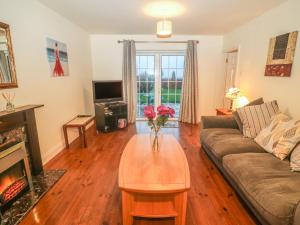 a living room with a couch and a table with flowers on it at Seagaze in Youghal