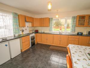 a kitchen with wooden cabinets and a sink at Gapple Cottage in Ballyboe