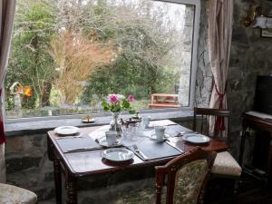 a wooden table with a vase of flowers on top of a window at Dun na Ron in Oughterard