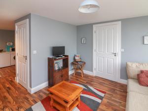 a living room with a couch and a table at Silver Birch House in Laune Bridge