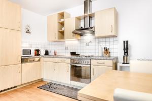 ビュルサーベルクにあるAppartement Ideal by A-Appartmentsの白いキャビネットと木製テーブル付きのキッチン