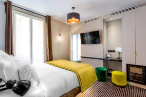 ein Hotelzimmer mit einem Bett und einem TV in der Unterkunft Hotel Bridget in Paris