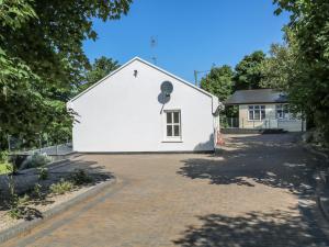 una casa bianca con finestra e vialetto di Hidden Gem Cabin a Dungloe