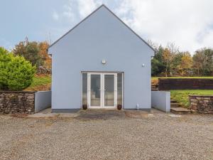 a white house with a glass door in a yard at Silver Birch House in Laune Bridge