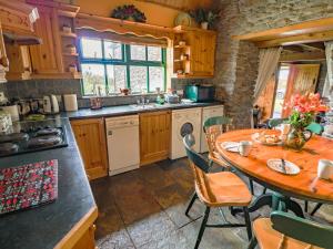 a kitchen with a table and a table and chairs at An Nead in Ballydavid