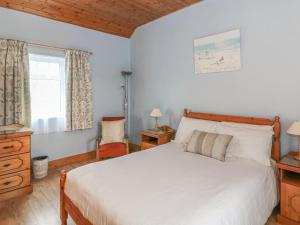 um quarto com uma cama branca e uma janela em Rose Cottage em Ramsgrange