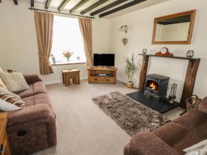 a living room with a couch and a fireplace at Penrhyddion Ucha in Capel Garmon