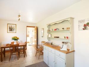 een keuken met een tafel en een eetkamer bij Marsh Cottage in Ashbourne