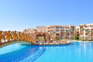 a large swimming pool with a bridge in front of a resort at Parrotel Lagoon Waterpark Resort in Sharm El Sheikh
