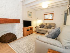 a living room with a couch and a fireplace at Fishermans Cottage in Conwy
