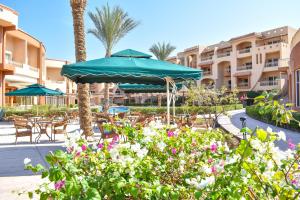 a patio with tables and umbrellas in a resort at Parrotel Lagoon Waterpark Resort in Sharm El Sheikh