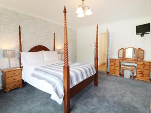 - une chambre avec un lit et une commode avec un miroir dans l'établissement Leigh Holt, à Shepton Mallet