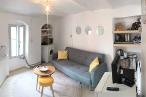 uma sala de estar com um sofá azul e uma mesa em Casa dei Rossi em Badalucco