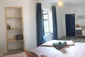 1 dormitorio con 1 cama con cortinas azules y ventana en Casa dei Rossi, en Badalucco