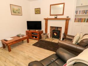 a living room with a couch and a fireplace at 3 Guys Cottages in Long Preston