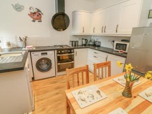 a kitchen with a wooden table and a kitchen with white cabinets at 3 Guys Cottages in Long Preston