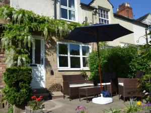 a patio with a table and an umbrella at 17 Riverside in Oakamoor