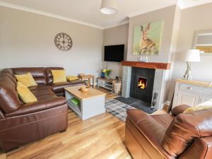a living room with a couch and a fireplace at Longforth Farm Cottage in Gillespie