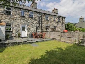 an old stone house with a wooden fence at Preswylfa in Betws-y-coed
