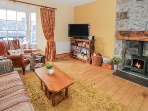 a living room with a couch and a fireplace at Castle Apartment in Conwy