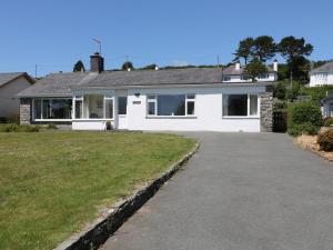 a white house with a driveway in front of it at Cae Glas in Pwllheli