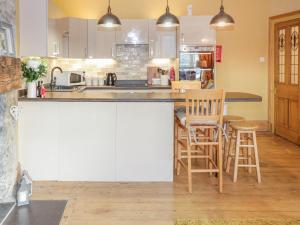 a kitchen with a counter with chairs and a counter top at Castle Apartment in Conwy