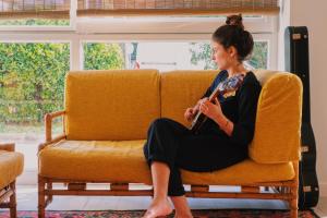 a woman sitting on a couch playing a guitar at Blai Blai Hostel in Zarautz