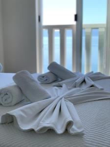 una pila de toallas y toallas en una cama en Villa Orca, en Podaca