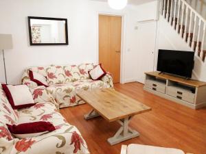 uma sala de estar com um sofá e uma televisão em 4 Bredon Court em Newquay