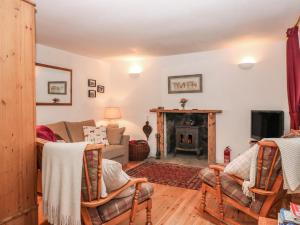 un salon avec un canapé et une cheminée dans l'établissement Creag Mhor Cottage, à Dornie