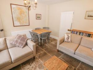 a living room with two couches and a table at Stanfree House in Matlock