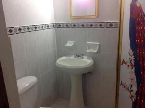 une salle de bains avec lavabo et toilettes dans l'établissement Hotel Providencia, à Talpa de Allende