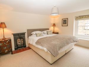 a bedroom with a large bed and a fireplace at Stanfree House in Matlock