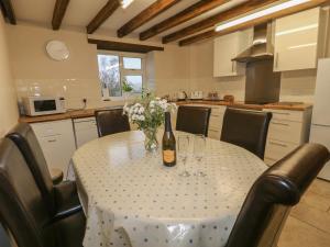 a table with a bottle of wine and flowers on it at Woodlands Farm in Ashbourne