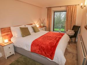 um quarto com uma cama grande e uma janela em Woodlands Farm em Ashbourne