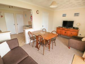 a living room with a table and chairs and a tv at Surf in Hunstanton