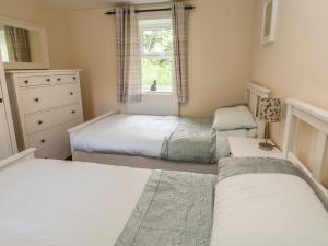 a bedroom with two beds and a window at Witton View Cottage in Bishop Auckland