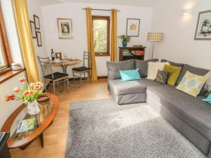 a living room with a couch and a table at Doe Foot Cottage in Ingleton