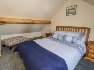 een slaapkamer met een bed en een stoel erin bij The Hayloft in Husthwaite