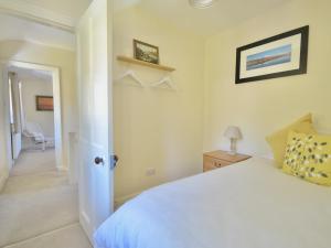 una camera con letto bianco e corridoio di Ling Fell Cottage a Ulverston