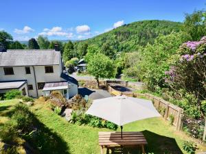 un tavolo con ombrellone in erba di Ling Fell Cottage a Ulverston