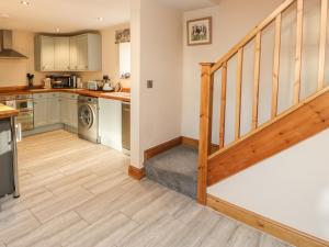 a kitchen with a staircase leading up to a living room at The Stables in Barnard Castle