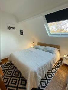 a bedroom with a large white bed with a window at La VILLA en BAIE in Le Crotoy