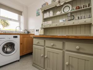 a laundry room with a washer and a washing machine at Mollys Cottage in St. Just