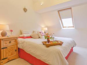 a bedroom with a bed with a tray of fruit on it at The Bolthole in Okehampton