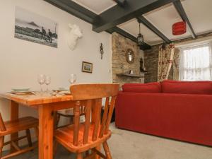a living room with a table and a red couch at Mollys Cottage in St Just